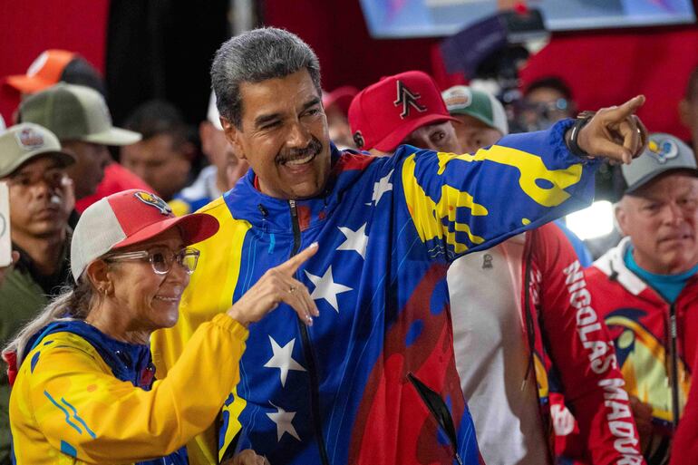 El presidente de Venezuela, Nicolás Maduro (d), celebra con Cilia Flores tras conocer los resultados de las elecciones presidenciales este lunes, en Caracas (Venezuela). Maduro, en el poder desde 2013, pidió este domingo "respeto a la voluntad popular" tras ser proclamado como mandatario reelecto, luego de unos comicios en los que compitió contra nueve contendientes, entre ellos el abanderado de la oposición mayoritaria, Edmundo González Urrutia.