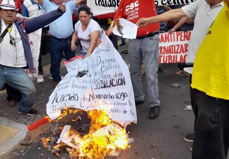 Integrantes de la Corriente Sindical Clasista (CSC) se manifestaron hoy frente al MTESS y realizaron una quema simbólica del acuerdo que firmaron algunas centrales obreras con el presidente Santiago Peña