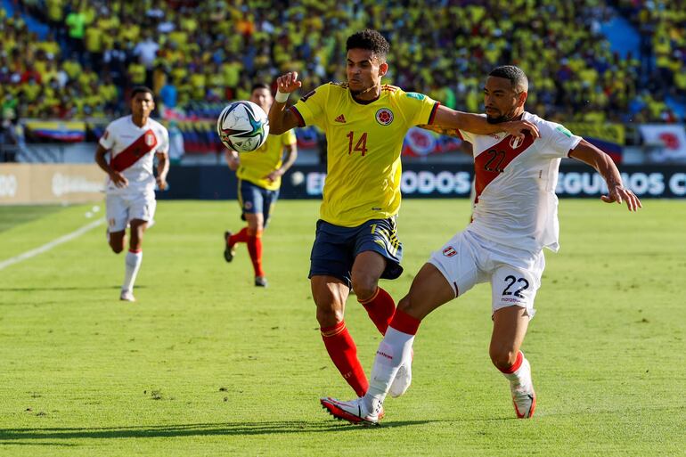 Luis Díaz (i), jugador de la selección de Colombia, disputa un balón con Alexander Callens, futbolista de la selección de Perú, en un partido de las Eliminatorias Sudamericanas al Mundial Qatar 2022 en el estadio Metropolitano, en Barranquilla, Colombia.