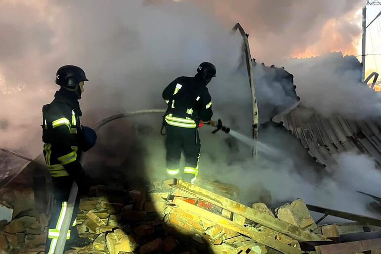 Bomberos ucranianos trabajan en el sitio de un bombardeo ruso este jueves en la localidad de Lutsk.