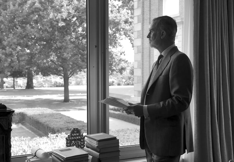 El soberano español Felipe VI mirando el jardín desde el ventanal de su despacho del Palacio de la Zarzuela. (EFE/Casa de S. M. el Rey)
