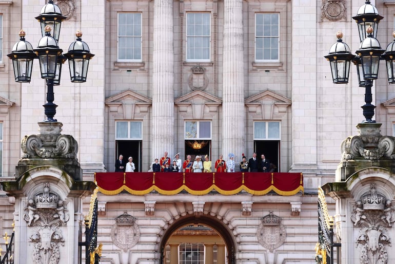 Familia real de Gran Bretaña en el balcón del Palacio de Buckingham. (Photo by HENRY NICHOLLS / AFP)