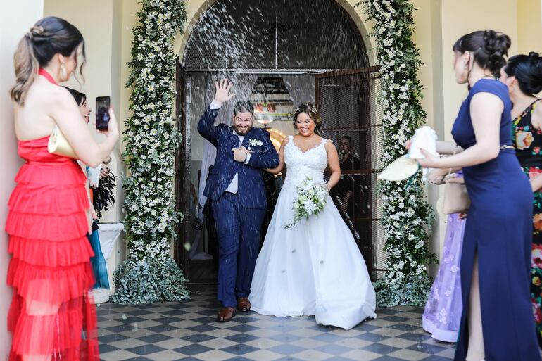 Los recién casados a la salida de la iglesia recibidos por sus amigos y familiares.