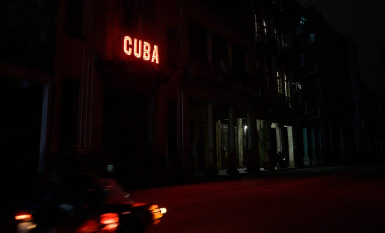 Un cartel ilumina una calle bloqueada durante el apagón nacional en La Habana, Cuba.