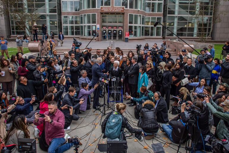 Joan VanderMolen (centro con cabello blanco), hermana de Kitty Menéndez, y el abogado Mark Geragos hablan con la prensa frente al juzgado de Van Nuys West después de asistir a una audiencia sobre el estado de la condena por asesinato de Lyle y Erik Menéndez.