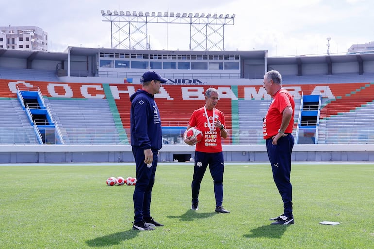 El argentino Gustavo Alfaro (d), entrenador de la selección de Paraguay conversa con sus asistentes en la previa del entrenamiento del plantel en el estadio Félix Capriles, en Cochabamba, Bolivia.