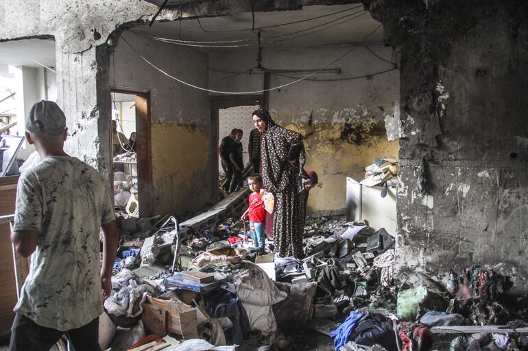 Los palestinos inspeccionan los daños tras un ataque israelí a la escuela Al Tabaín en el barrio de Daraj Tuffah de Gaza.