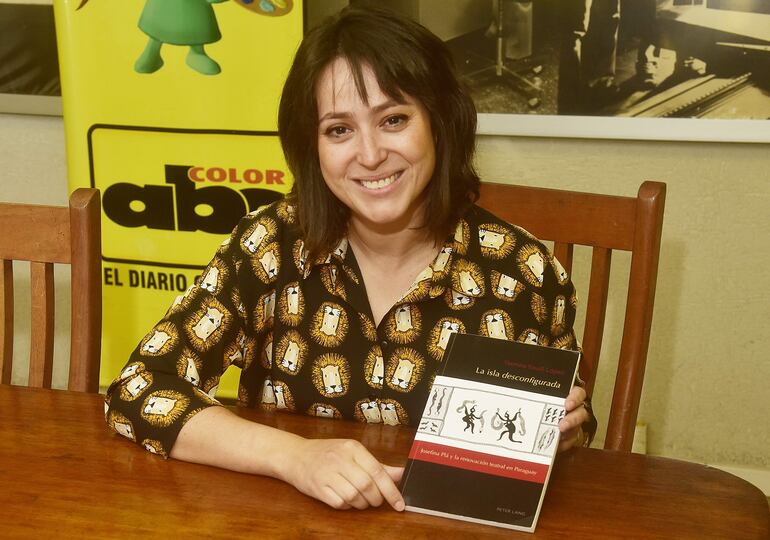 Yasmina Yousfi López exhibe la portada de su libro "La isla desconfigurada", en la que resume su investigación acerca del trabajo teatral de Josefina Plá.