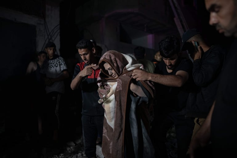 Rescatistas sacan a personas heridas de un edificio dañado por un bombardeo israelí en Rafah, este sábado.

