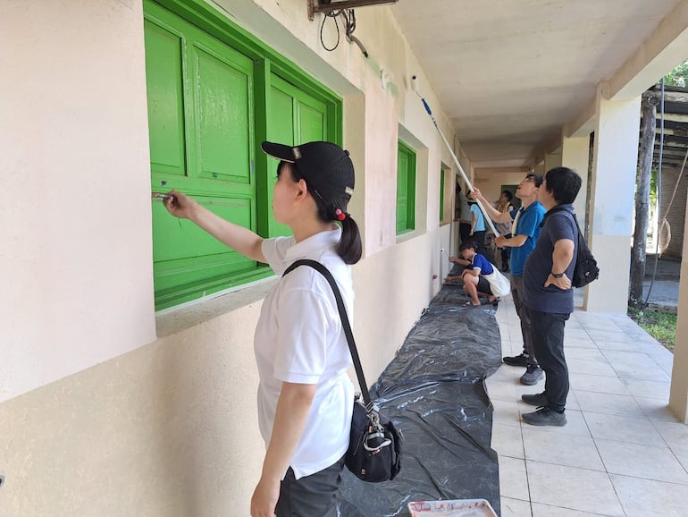 Los jóvenes orientales en pleno trabajo de pintura del local del emblemático colegio de Fuerte Olimpo.