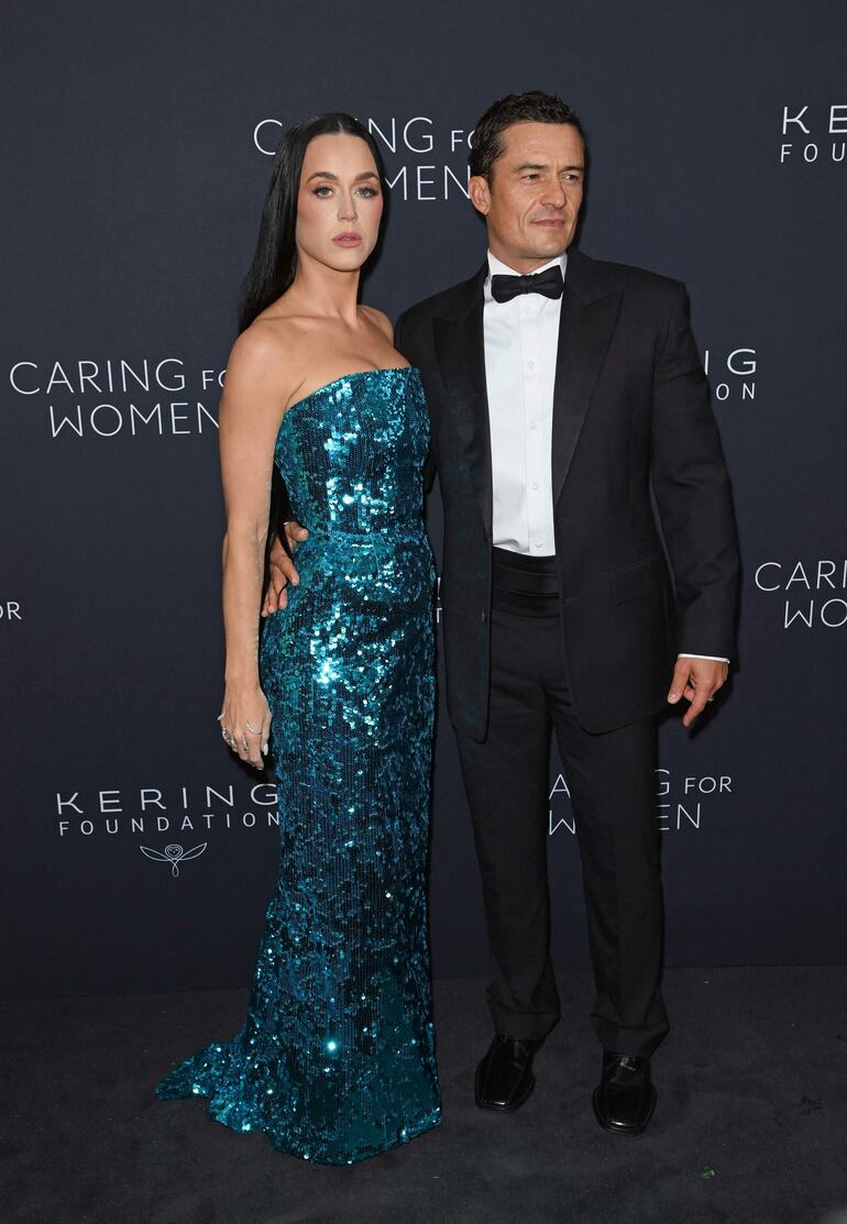 La cantante estadounidense Katy Perry y el actor inglés Orlando Bloom llegaron de la manito y muy elegantes a la cena Caring for Women de la Fundación Kering. (Andrea RENAULT / AFP)