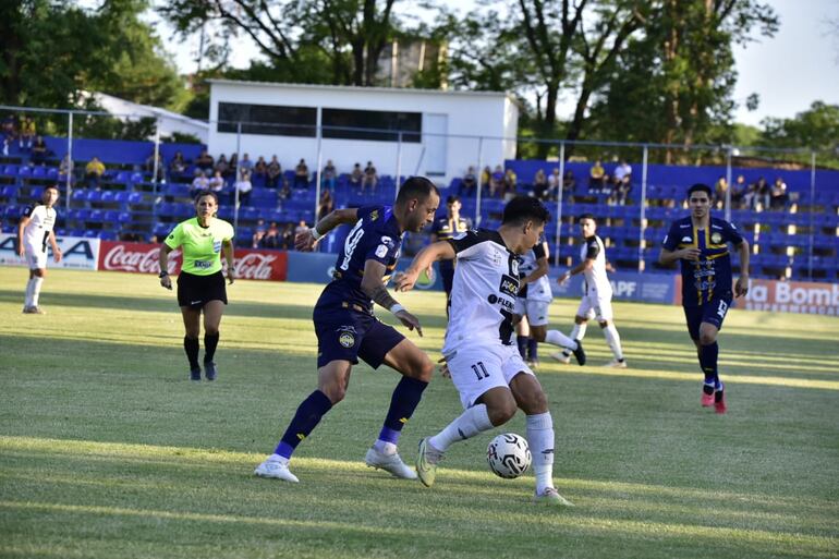 Sergio Mendoza (Trinidense) pelea el balón con Óscar Ruíz (Tacuary).