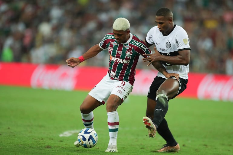 John Kennedy (i) de Fluminense disputan el balón con Jhohan Romaña de Olimpia  en un partido de los cuartos de final de la Copa Libertadores entre Fluminense y Olimpia en el estadio Maracaná en Río de Janeiro (Brasil).