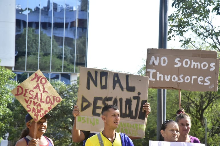 "No al desalojo; no somos invasores", rezan los carteles de los pobladores.