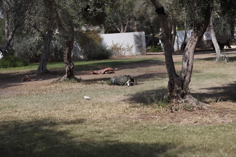 Cuerpos de militantes de Hamás yacen en el suelo en el kibutz de Kfar Aza, Israel, junto a la frontera con Gaza.
