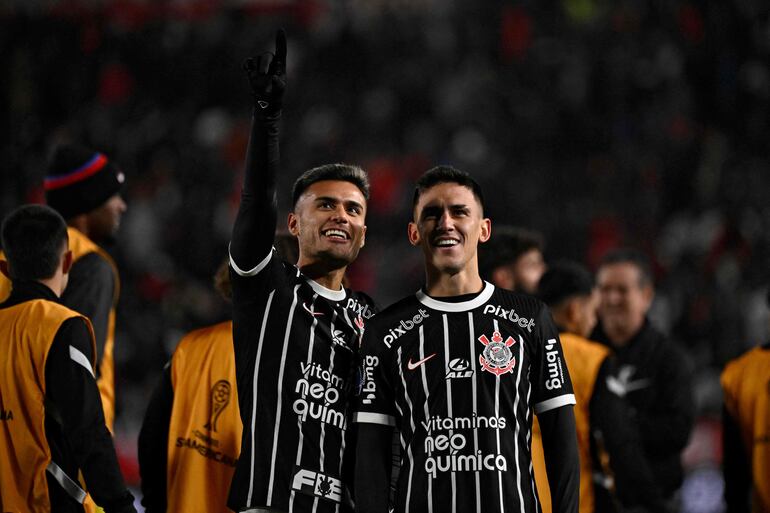 El centrocampista argentino del Corinthians Fausto Vera (izq.) y el centrocampista paraguayo Matías Rojas saludan a los aficionados tras derrotar a Estudiantes en la tanda de penales de la Copa Sudamericana.