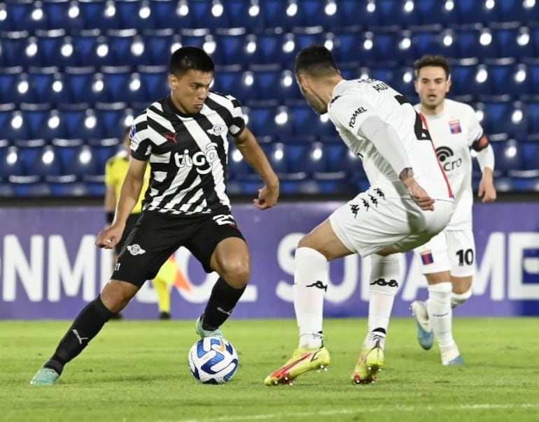 El jugador de Libertad, Diego Gómez, encara la marca de los defensores de Tigre.