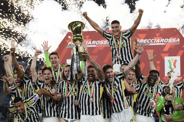 TOPSHOT - Juventus' Brazilian defender #06 Danilo holds the trophy as Juventus players celebrate after winning the Italian Cup Final between Atalanta and Juventus at the Olympic stadium in Rome on May 15, 2024. (Photo by Filippo MONTEFORTE / AFP)
