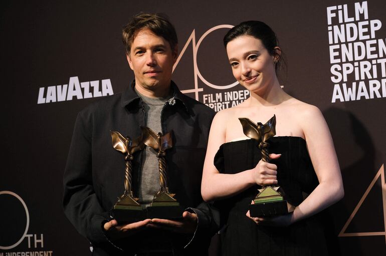 El cineasta Sean Baker y la actriz Mickey Madison posan con los premios obtenidos por "Anora" en los Spirit Awards.