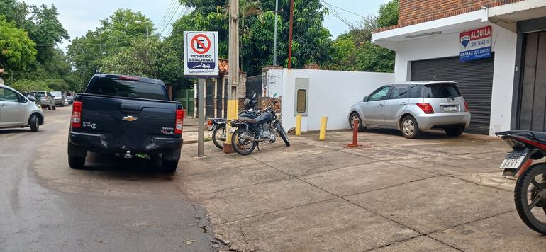 camioneta negra estacionada al lado de un cartel prohibido estacionar