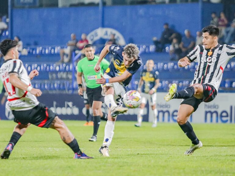 El argentino Tomás Rayer (c), futbolista de Sportivo Trinidense, ejecuta un remate en el partido frente a Libertad por la cuarta fecha del torneo Clausura 2024 del fútbol paraguayo en el estadio Luis Alfonso Giagni, en Villa Elisa.