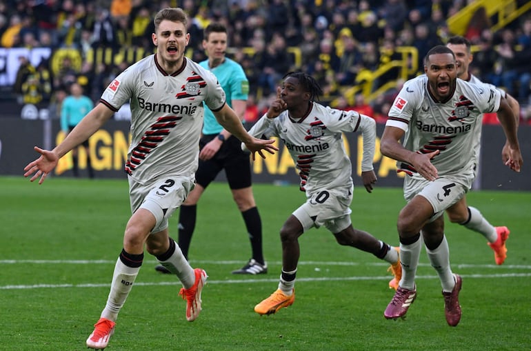 Bayer Leverkusen's Croatian defender #02 Josip Stanisic celebrates after scoring the equalising goal 1:1 during the German first division Bundesliga football match between Borussia Dortmund and Bayer Leverkusen in Dortmund, western Germany, on April 21, 2024. (Photo by Sascha Schuermann / AFP) / DFL REGULATIONS PROHIBIT ANY USE OF PHOTOGRAPHS AS IMAGE SEQUENCES AND/OR QUASI-VIDEO