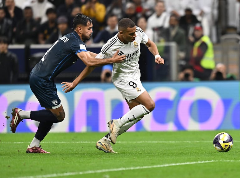 Kylian Mbappe (d) del Real Madrid se desprende de la marca de Sergio Barreto del Pachuca, en la final por la Copa Intercontinental, donde anotó el primer gol para el cuadro español, al minuto 37.