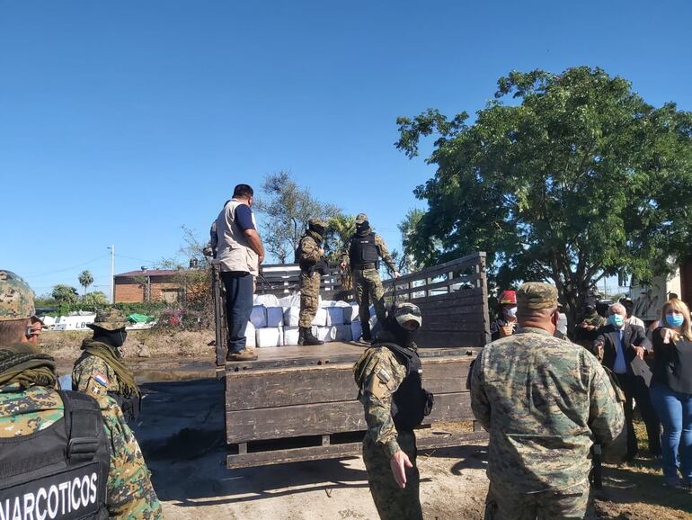 Agentes antinarcóticos bajan los panes de cocaína para poder quemarlos en una fosa.