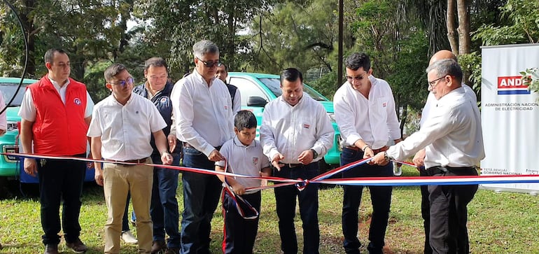 Momento en que las autoridades de la ANDE desatan la cinta de la Sección de Operación de Vehículo, durante la entrega de cinco camionetas.