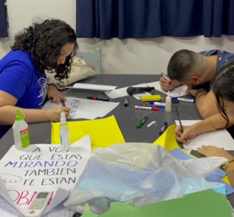 Estudiantes de la UNA confeccionando carteles.