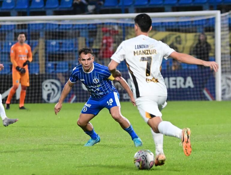 El volante de Guaraní, Agustín Manzur, encara con balón dominado la marca de Derlis Orué.