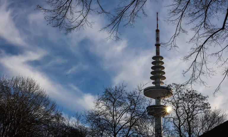 El sol brilla tras la torre de televisión de Hamburgo, Alemania