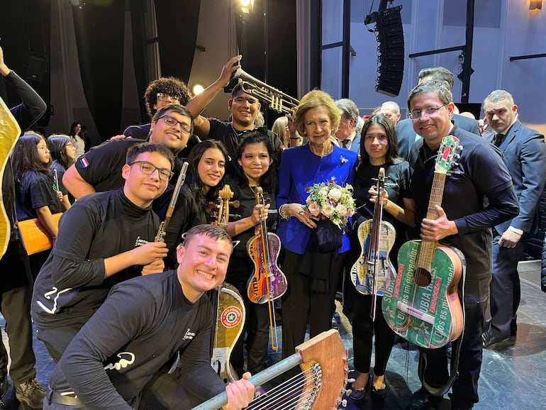 Integrantes de la Orquesta de Instrumentos Reciclados de Cateura y su director, Favio Chávez, posan junto a la reina Sofía de España tras el concierto de la agrupación en Madrid.