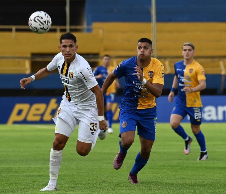 Paul Riveros, de Guaraní, disputa un balón con Marcelo Pérez, de Luqueño.