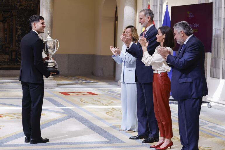 El tenista Carlos Alcaraz es aplaudido por el rey Felipe V, la reina Letizia, la ministra de Educación, Formación Profesional y Deportes y portavoz del Gobierno, Pilar Alegría, y del presidente del Consejo Superior 
de Deportes (CSD), José Manuel Rodríguez Uribes, al recibir el Premio Rey Felipe al mejor deportista español del año en el palacio de El Pardo en Madrid. (EFE/ Javier Lizón)
