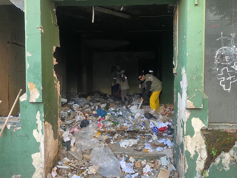 Policía Municipal de Asunción interviene y limpia un edificio abandonado lleno de basura.