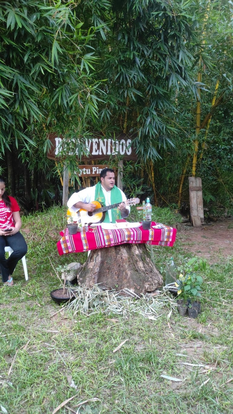 El padre Simón Martínez toca la guitarra durante una misa.