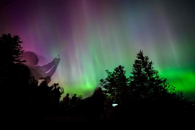 Los espectadores contemplan y fotografían la aurora boreal en el mirador Chanticleer Point en la garganta del río Columbia en las primeras horas de la mañana del 11 de mayo de 2024 en Latourell, Oregón.