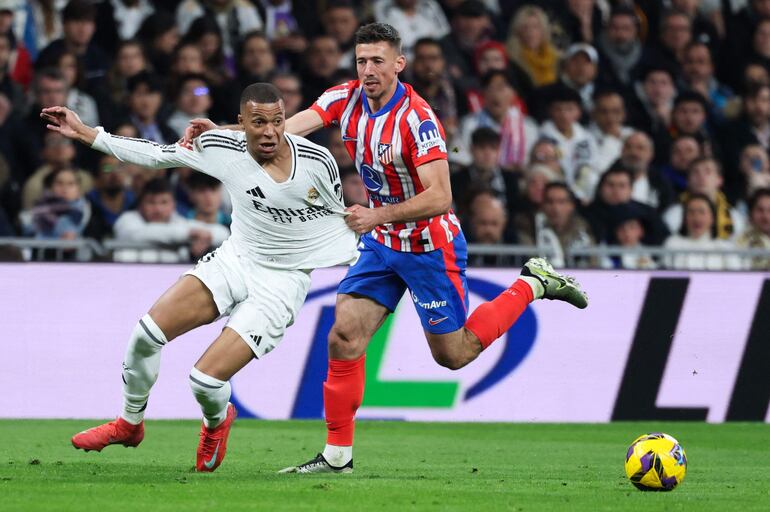 Real Madrid's French forward #09 Kylian Mbappe is tugged by Atletico Madrid's French defender #15 Clement Lenglet during the Spanish league football match between Real Madrid CF and Club Atletico de Madrid at Santiago Bernabeu Stadium in Madrid on February 8, 2025. (Photo by Thomas COEX / AFP)