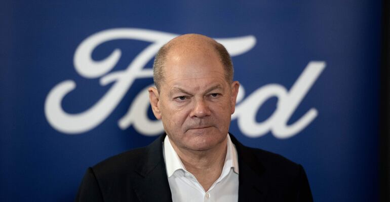 El canciller alemán Olaf Scholz se encuentra frente al logotipo del fabricante de automóviles Ford en Colonia, Alemania. Scholz pidió este martes, durante su visita a la planta de Ford en Colonia, incentivos para la compra de vehículos eléctricos en toda Europa, y afirmó que dará un paso adelante y luchará por cada puesto de trabajo de la industria.