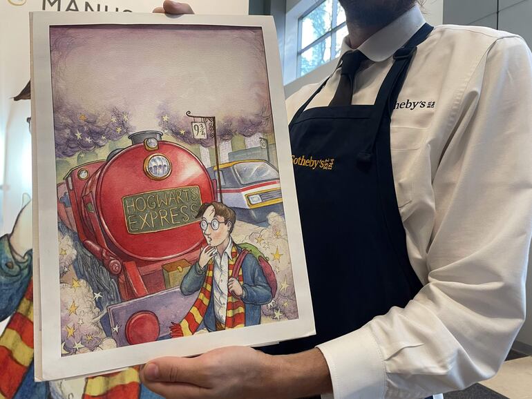 Un empleado de Sotheby's muestra la primera portada original de 'Harry Potter y la piedra filosofal', elaborada en 1997 por el artista británico Thomas Taylor, este viernes en la sede de esta casa de subastas en Nueva York (EE.UU.). La acuarela de la portada original de 'Harry Potter y la piedra filosofal', la primera imagen jamás concebida del 'niño que sobrevivió', saldrá a subasta en Nueva York el próximo 26 de junio de la mano de la casa Sotheby's.