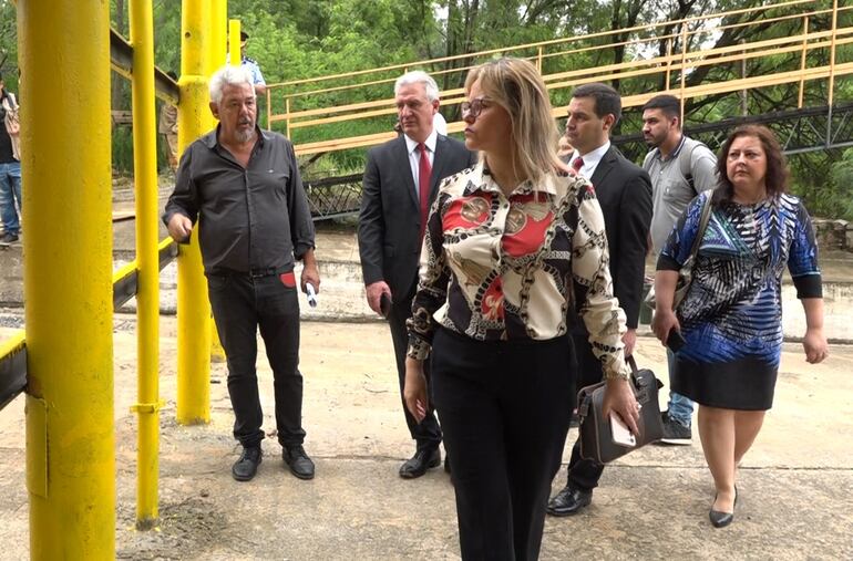 La fiscala Gladys González y detrás, el abogado Enrique Bacchetta, en un recorrido por la calle a través de la que la camioneta Toyota Fortuner fue arrastrada por el raudal hasta caer al cauce del arroyo Lambaré. 