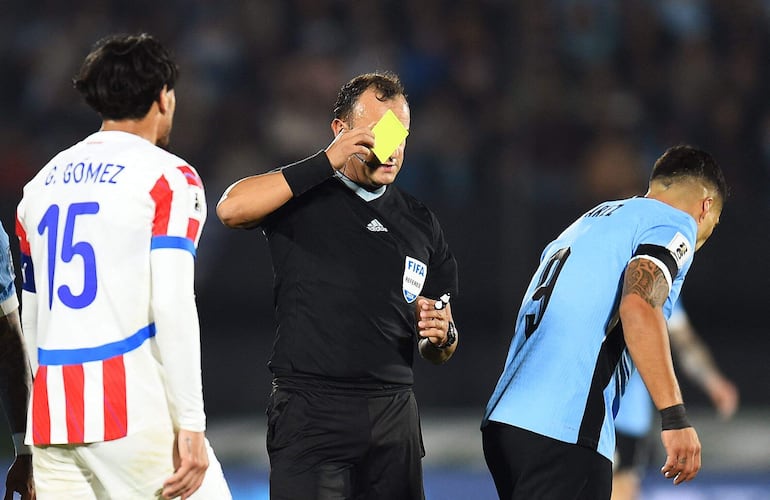 Gustavo Gómez (15), jugador de la selección de Paraguay, es amonestado por el árbitro Darío Herrera en el partido frente a Uruguay por la séptima fecha de las Eliminatorias Sudamericanas en el estadio Centenario, en Montevideo.