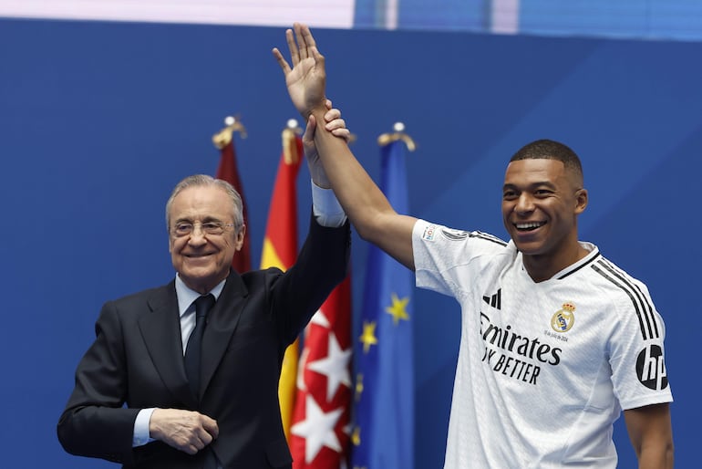 El jugador francés Kylian Mbappé (d) y el presidente Florentino Pérez en la presentación como jugador del Real Madrid en el estadio Santiago Bernabéu, en Madrid, España.