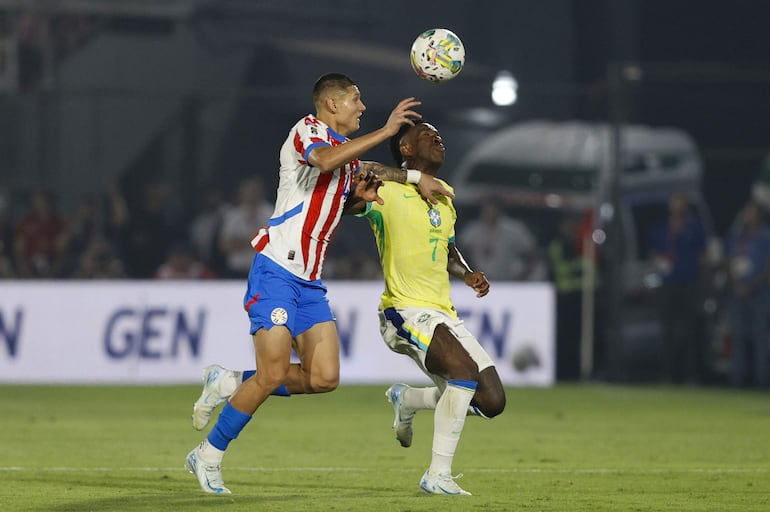 Juan José Cáceres (i), jugador de la selección de Paraguay, pelea por el balón en el partido frente a Brasil por las Eliminatorias Sudamericanas 2026 en el estadio Defensores del Chaco, en Asunción, Paraguay.