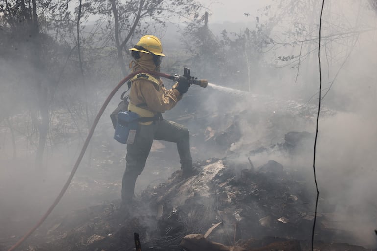 Un bombero trabaja en una zona de incendio en el banco San Miguel, el domingo.