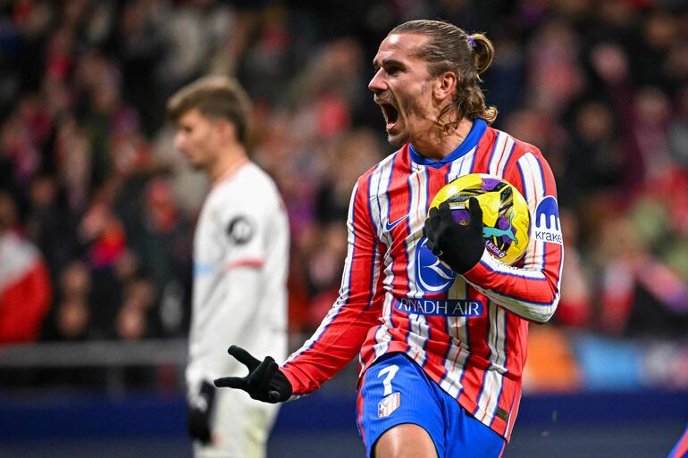 Atletico Madrid's French forward #07 Antoine Griezmann celebrates after scoring their second goal during the Spanish league football match between Club Atletico de Madrid and Sevilla FC at the Metropolitano stadium in Madrid on December 8, 2024. (Photo by JAVIER SORIANO / AFP)