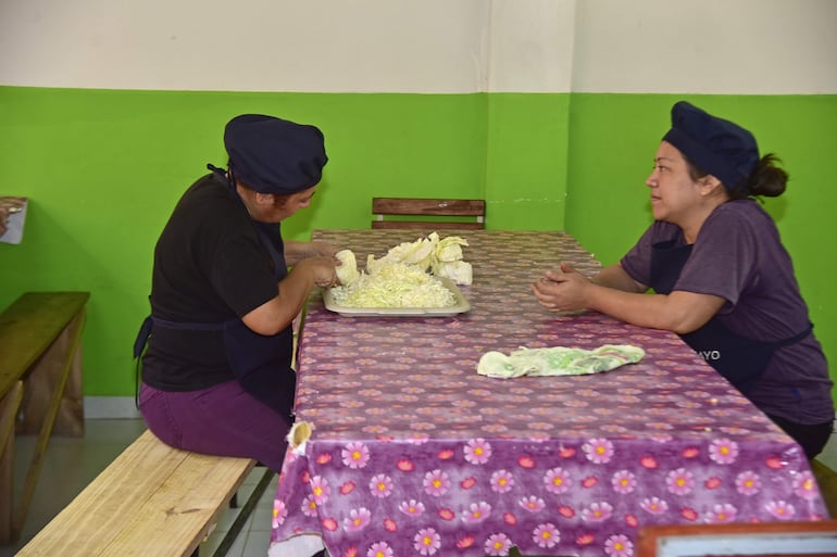 Mamás cortan repollo para la ensalada del almuerzo escolar en una escuela pública del Departamento Central.