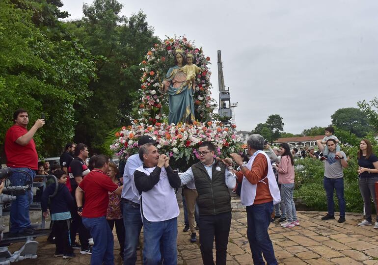 Devotos de la virgen cargan con la imagen para llevarla hasta el barco que recorrió por el río Paraguay en el marco de la procesión.