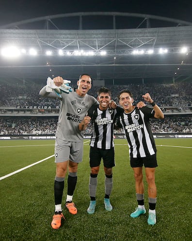 Los paraguayos Gatito Fernández (i) y Mati Segovia (d) celebran la victoria de Botafogo  con un compañero de equipo en el estadio Nilton dos Santos (Foto gentileza Botafogo).